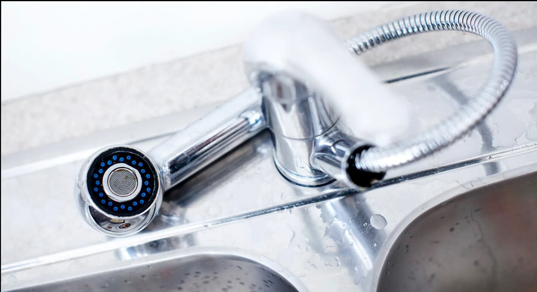 Close-up of a shiny chrome kitchen faucet with sprayer